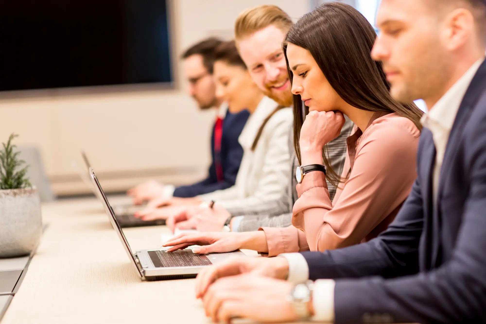 Team members working together on laptops during an in-person AI training session